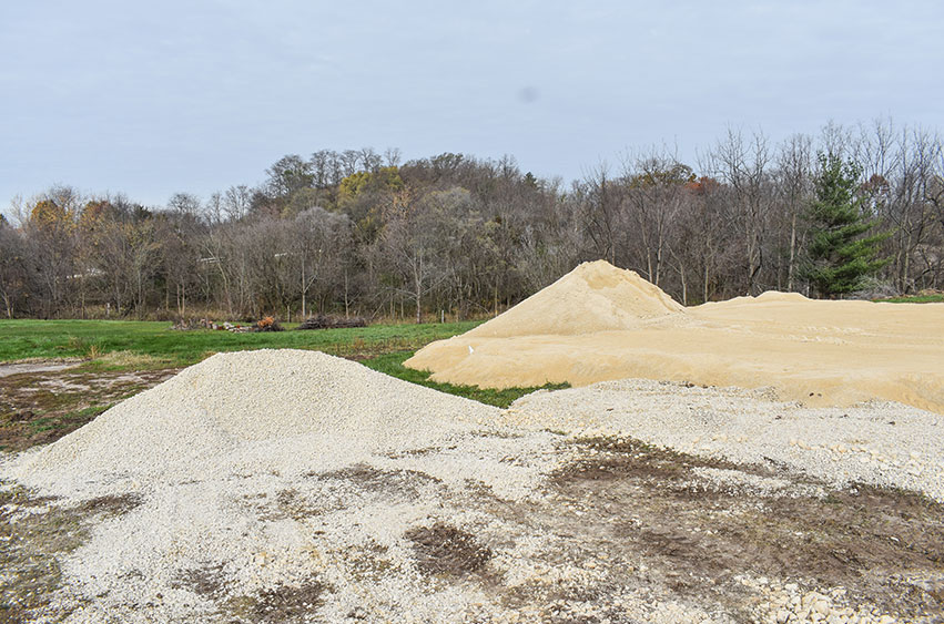 Sand and gravel piles staged for site preparation in Iowa.